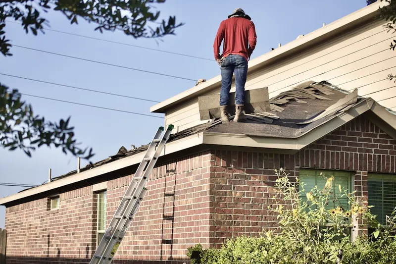 Professional roofer working on a residential roof in Upper Brookville